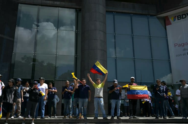 Un manifestante muestra una bandera venezolana durante una protesta frente a las oficinas de Naciones Unidas en Caracas el 30 de julio de 2024 (YURI CORTEZ)