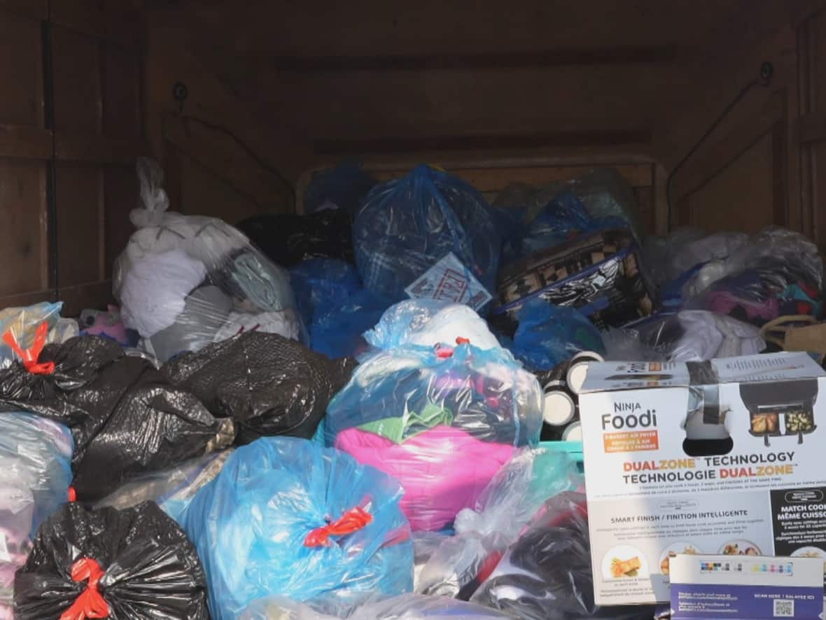 Leonard and Amanda Cardinal loaded a trailer with garbage bags filled with clothes, blankets and pillows, among other items, to help evacuees in High Level, Alta. (Luke Ettinger/CBC - image credit)