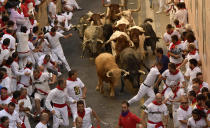 <p>Revellers run in front of Cebada Gago fighting bulls during the first running of the bulls at the San Fermin Festival, in Pamplona, northern Spain, July 7, 2017. (Alvaro Barrientos/AP) </p>