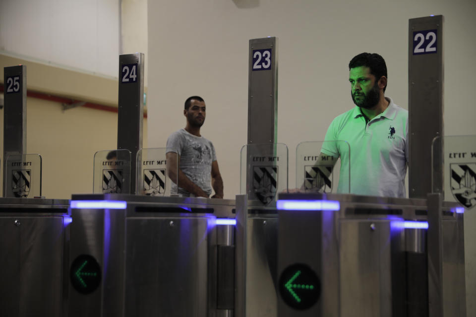 In this Thursday, July 11, 2019 photo, Palestinians stand in front of a biometric gate as they enter Israel at the Qalandia crossing in Jerusalem. Israel’s military has invested tens of millions of dollars to upgrade West Bank crossings and ease entry for Palestinian workers. But while the upgrades may have eased crossing for Palestinians entering Israeli daily for work, critics say they are a sign of the ossification of Israel’s 52-year occupation of the West Bank and slam the military’s use of facial recognition technology as problematic. (AP Photo/Sebastian Scheiner)