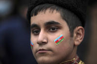 Azerbaijani soldiers and civilians celebrate the transfer of the Lachin region to Azerbaijan's control, as part of a peace deal that required Armenian forces to cede the Azerbaijani territories they held outside Nagorno-Karabakh, in Aghjabadi, Azerbaijan, Tuesday, Dec. 1, 2020. Azerbaijan has completed the return of territory ceded by Armenia under a Russia-brokered peace deal that ended six weeks of fierce fighting over Nagorno-Karabakh. Azerbaijani President Ilham Aliyev hailed the restoration of control over the Lachin region and other territories as a historic achievement. (AP Photo/Emrah Gurel)