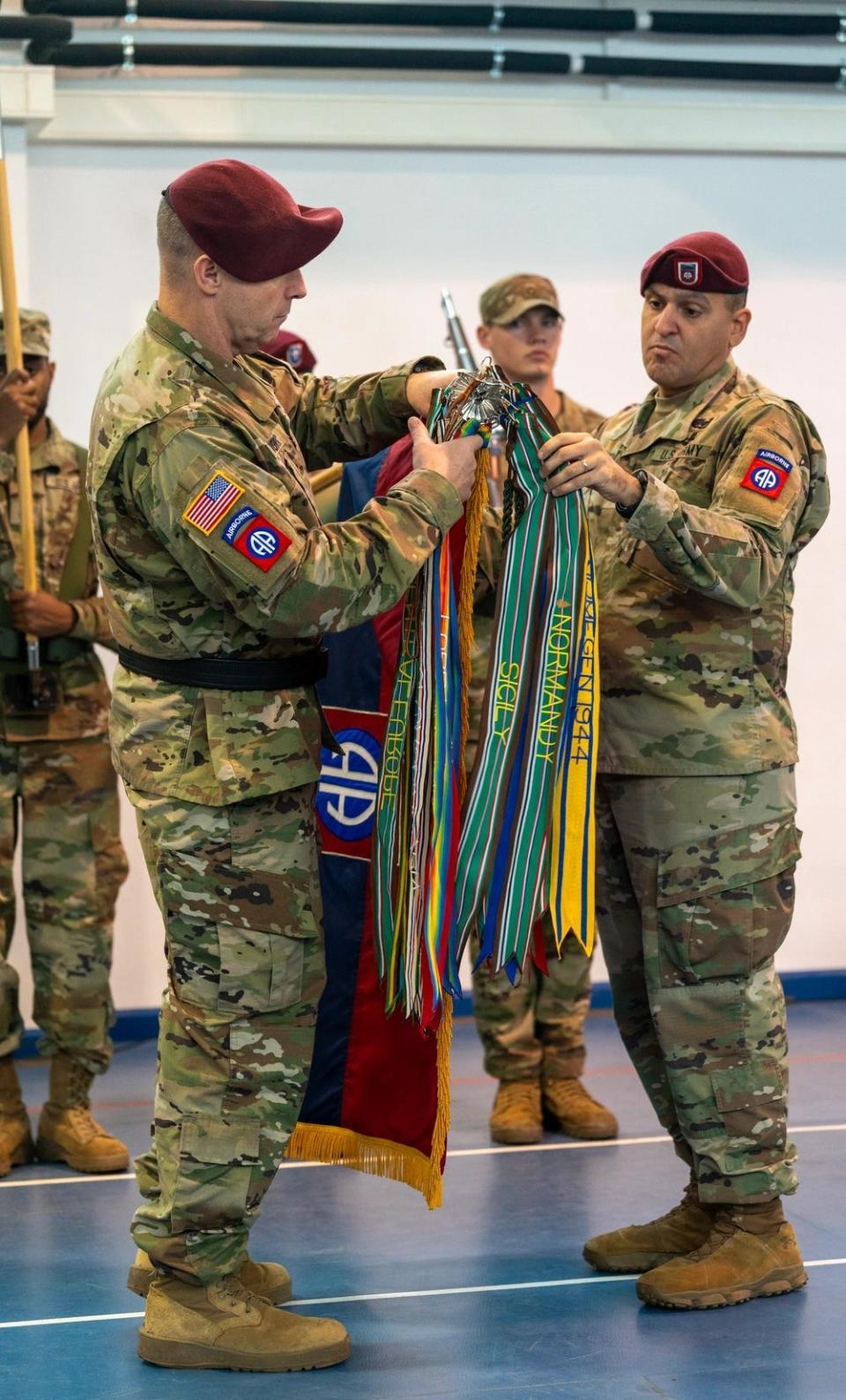 Maj. Gen. Pat Work, commander of the 82nd Airborne Division and Command Sgt. Maj. Randolph Delapena uncase colors during a Dec. 15, 2023, transfer of authority ceremony between the 82nd and 10th Mountain Division at Mihail Kogalniceanu Air Base, Romania.