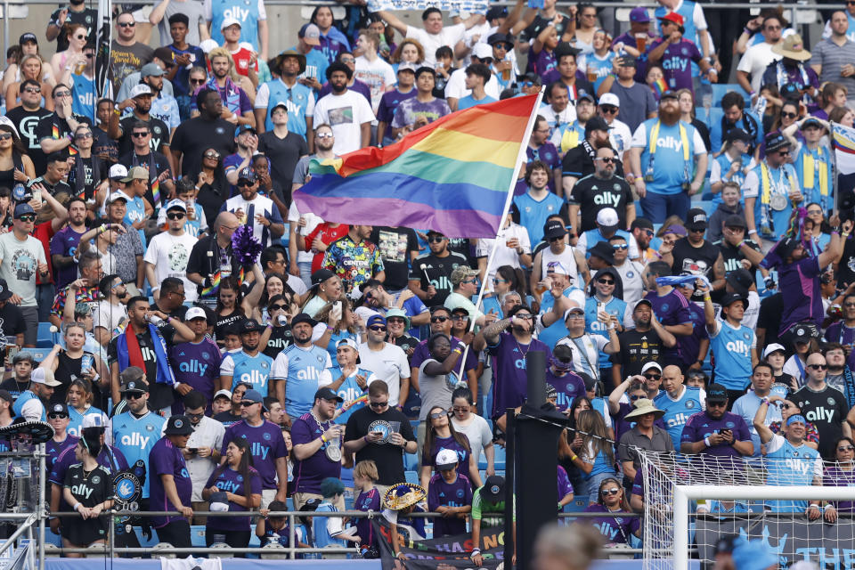 A fan waves a Pride Flag prior to a MLS soccer match between the Seattle Sounders and the Charlotte FC, Saturday, June 10, 2023, in Charlotte, N.C. (AP Photo/Brian Westerholt)