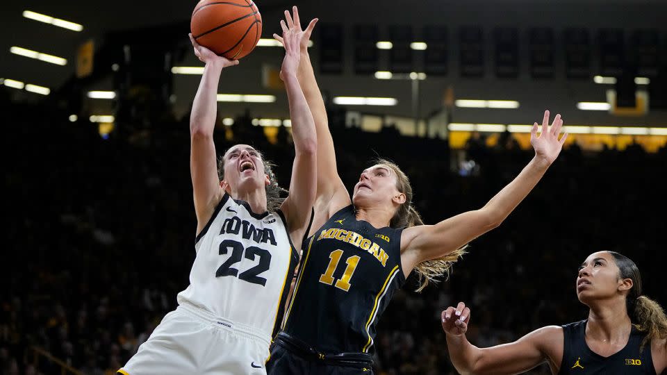 Clark, left, pulls up for a shot as Michigan guard Greta Kampschroeder (No. 11) defends during the second half of Thursday's game. - Matthew Putney/AP