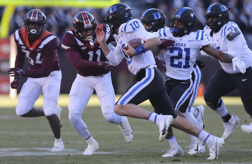 Duke quarterback Riley Leonard (10) runs the ball while defended by Virginia Tech's Alan Tisdale and Amare Barno (11) in the first half of an NCAA college football game in Blacksburg Va., Saturday Nov. 13 2021. (Matt Gentry/The Roanoke Times via AP)