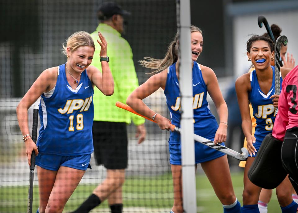 Maeve Shortt (left celebrates with Sophie Stanley and Kaylee Anthony (right) after scoring the only and winning goal for St. John Paul II against Nauset in field hockey Sept. 25 . Anthony assisted on the goal.
