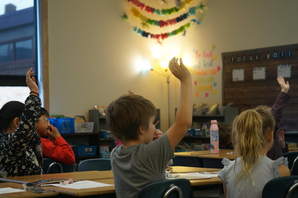 Students raise their hands to respond to a question during a reading lesson at Brooklyn Primary School in Baker City. (Alex Baumhardt/Oregon Capital Chronicle)