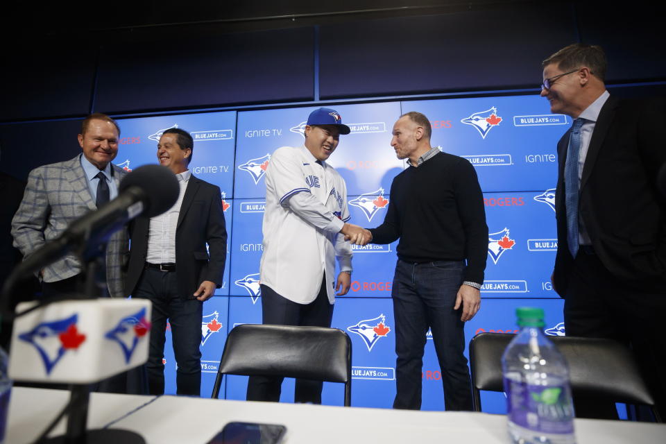 Toronto Blue Jays newly signed pitcher Hyun-Jin Ryu, center, shakes hands with Blue Jays president Mark Shapiro, during a news conference announcing his signing to the team in Toronto, Friday, Dec. 27, 2019. (Cole Burston/The Canadian Press via AP)