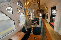 <p>A crew member shows the lounge car aboard the Train Suite Shiki-shima during a press preview in Tokyo. (Photo: STR/AFP/Getty Images) </p>