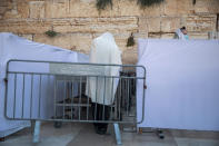 Ultra-Orthodox Jewish men pray in divided sections which allow a maximum of twenty worshipers in line with government measures to help stop the spread of the coronavirus, at the Western Wall, the holiest site where Jews can pray, in Jerusalem's Old City, Thursday, July 16, 2020. (AP Photo/Oded Balilty)