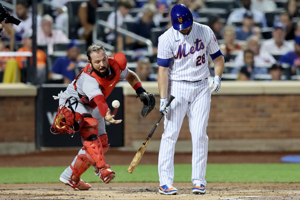 Aug 9, 2022; New York City, New York, USA; Cincinnati Reds catcher Austin Romine (28) attempts to play a foul ball by New York Mets first baseman Darin Ruf (28) during the first inning at Citi Field. Mandatory Credit: Brad Penner-USA TODAY Sports