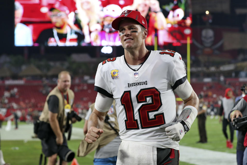 Tampa Bay Buccaneers quarterback Tom Brady (12) smiles as he runs off the field after an NFL football game against the Chicago Bears Sunday, Oct. 24, 2021, in Tampa, Fla. (AP Photo/Mark LoMoglio)