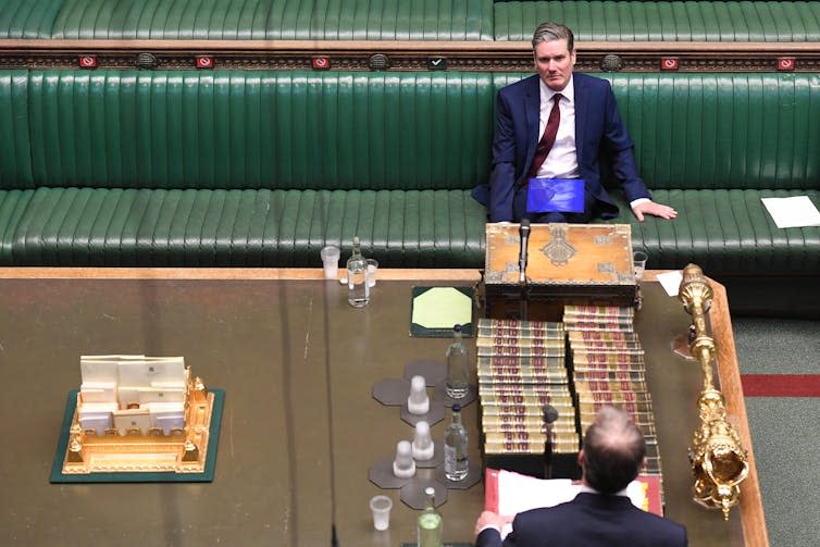 Keir Starmer sitting on the House of Commons green benches.