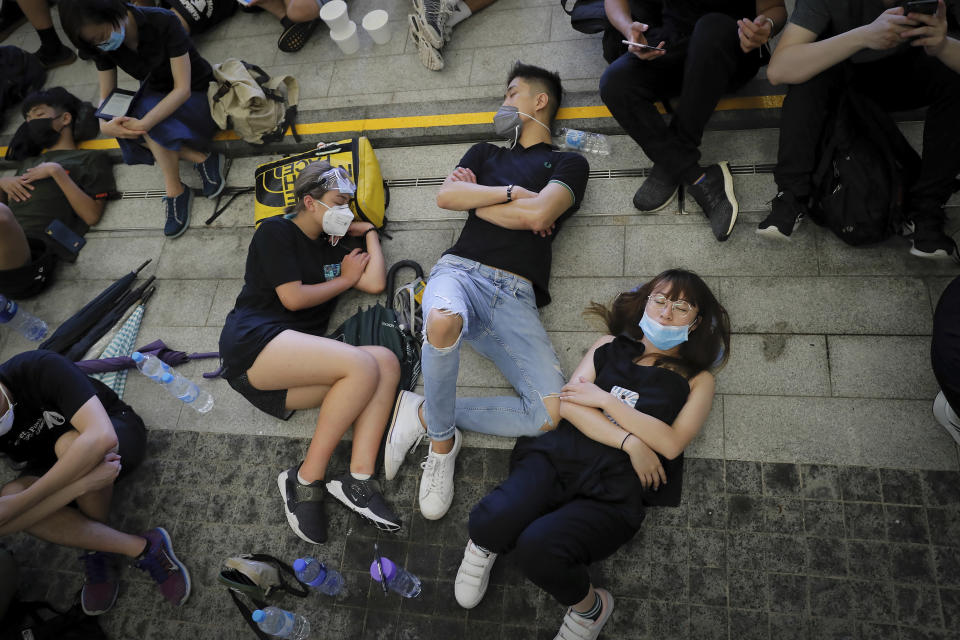 Protesters take a rest near the Legislative Council after staged a massive protest against the unpopular extradition bill in Hong Kong, Monday, June 17, 2019. Protesters in Hong Kong have left the streets, averting possible clashes with police by moving to areas near the city's government headquarters. (AP Photo/Kin Cheung)