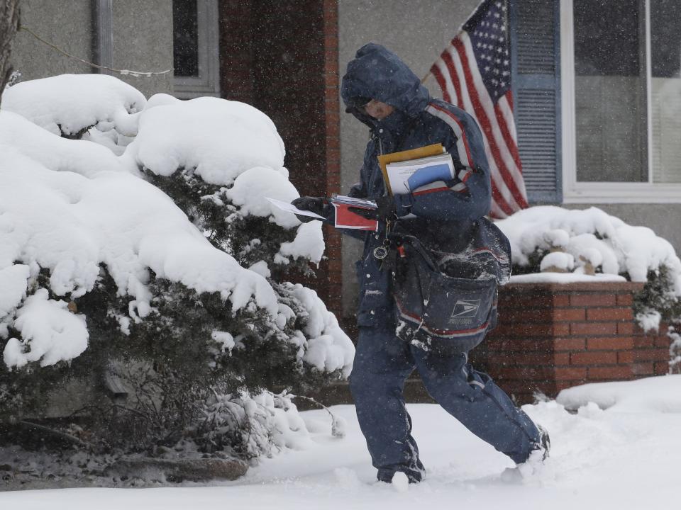 postal worker delivering snow in a snowstorm