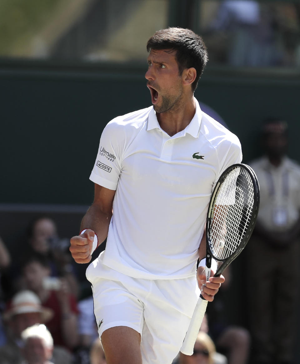Serbia's Novak Djokovic celebrates winning a game against Spain's Roberto Bautista Agut during a men's singles semifinal match on day eleven of the Wimbledon Tennis Championships in London, Friday, July 12, 2019. (AP Photo/Ben Curtis)