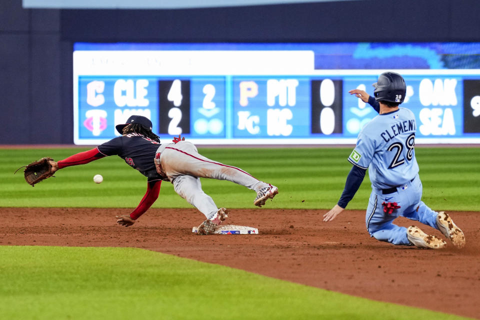 Washington Nationals shortstop CJ Abrams (5) misses the throw to second base as Toronto Blue Jays shortstop Ernie Clement (28) slides in during the third inning of a baseball game in Toronto on Monday, Aug. 28, 2023. (Andrew Lahodynskyj/The Canadian Press via AP)