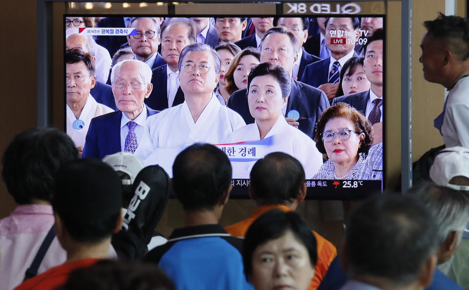 People watch a TV screen showing a live broadcast of South Korean President Moon Jae-in, center left, and his wife Kim Jung-sook during a ceremony to celebrate the Korean Liberation Day, marking the 74th anniversary of Korea's liberation from the Japanese colonial rule, at the Seoul Railway Station in Seoul, South Korea, Thursday, Aug. 15, 2019. The signs read: "Korean Liberation Day."(AP Photo/Ahn Young-joon)