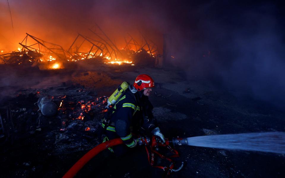A fireman battles flames at a Kyiv warehouse heavily damaged in the strikes