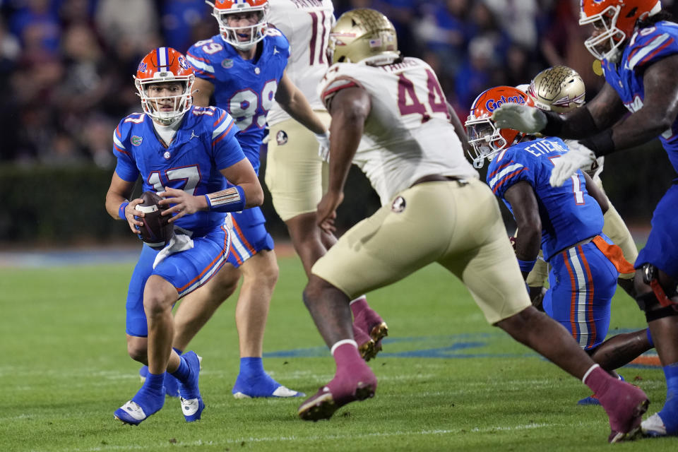 Florida quarterback Max Brown, left, looks for a receiver as Florida State defensive lineman Joshua Farmer (44) tries to stop him during the first half of an NCAA college football game Saturday, Nov. 25, 2023, in Gainesville, Fla. (AP Photo/John Raoux)