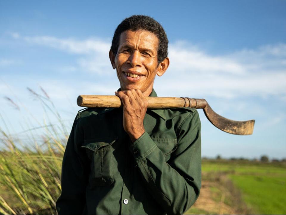 Deur Sok clears the area around his rice paddies in Sambour commune, near Kampong Thom. The canal built as part of WFP’s climate resilience work helps him keep his crops healthy (WFP/Samantha Reinders)