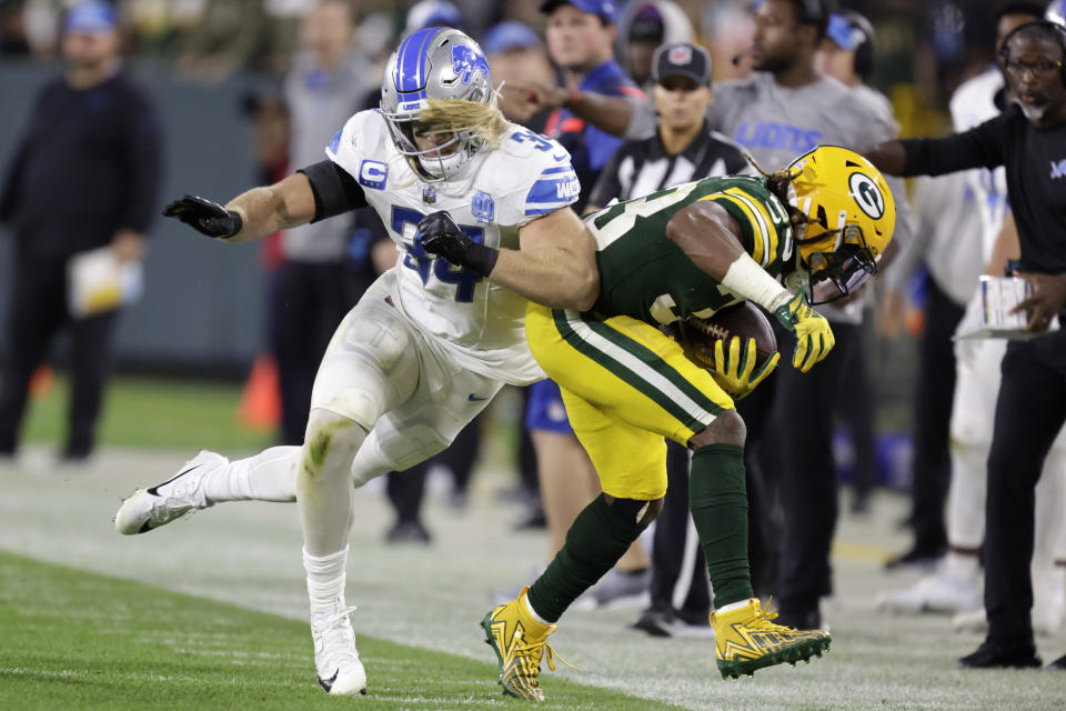 Green Bay Packers running back Aaron Jones (33) is pushed out of bounds by Detroit Lions linebacker Alex Anzalone (34) during the second half of an NFL football game, Thursday, Sept. 28, 2023, in Green Bay, Wis. (AP Photo/Matt Ludtke)