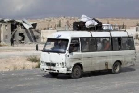 A bus passes near a site hit by what activists said were airstrikes carried out by the Russian air force in the town of Babila, in the southern countryside of Idlib, Syria, October 7, 2015. REUTERS/Khalil Ashawi