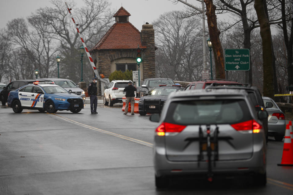 FILE- In this March 13, 2020 file photo, authorities control a line of motorists waiting to be tested for the coronavirus at Glen Island Park in New Rochelle, N.Y. New York City may be the epicenter of the coronavirus but the first sustained outbreak to be detected in the New York metropolitan area occurred in the suburb of New Rochelle. (AP Photo/John Minchillo, File)