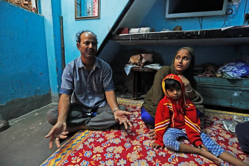 Fareeda and her husband Abdul Hanif sit with their four-year-old daughter inside their house in New Delhi