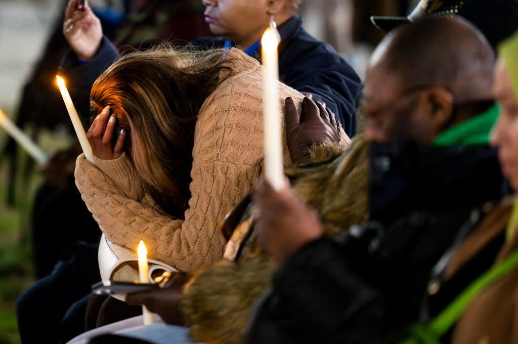 Donna Bruce holds her hand in her hands and cries during during a vigil for the homicide victims of 2023 on Wednesday, Jan. 3, 2023 in Baltimore. Mayor Brandon Scott hosted the vigil. (Kaitlin Newman /The Baltimore Banner via AP)