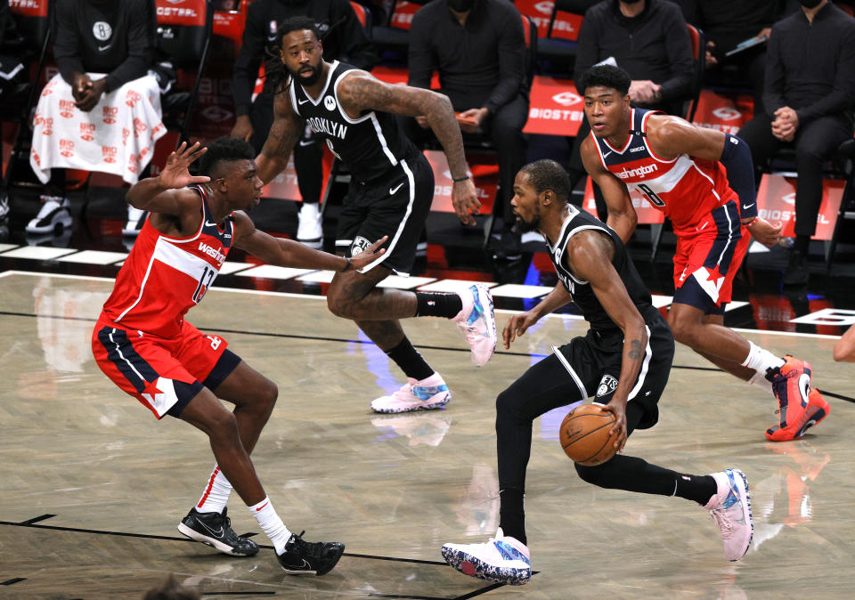 Kevin Durant dribbles the ball against the Wizards' Thomas Bryant.