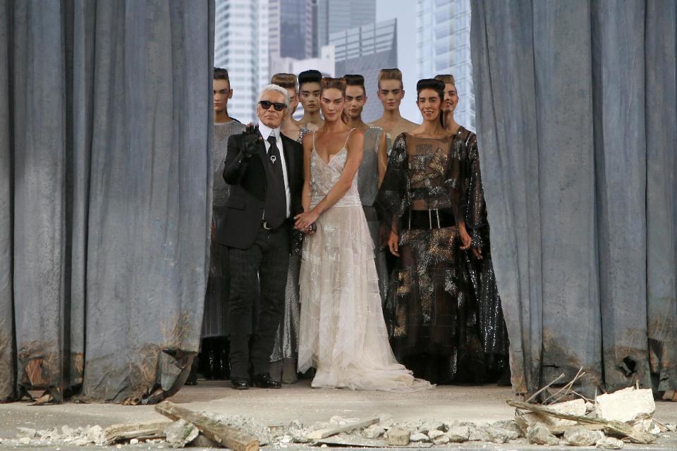 German fashion designer Karl Lagerfeld, left, surrounded by models, acknowledges applause following the presentation of the Haute Couture Fall-Winter 2013-2014 collection he designed for Chanel, Tuesday, July 2, 2013 in Paris. (AP Photo/Francois Mori)