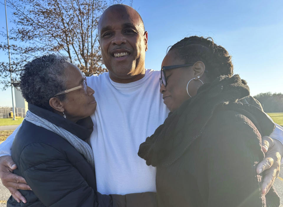In this photo provided by Laura Nirider, Brian Beals, center, who was exonerated on a murder charge and released from a downstate prison after 35 years behind bars, hugs his sister Pattilyn Beals, left, and niece Tamiko Beals outside Robinson Correctional Institution, in Robinson, Ill., on Tuesday, Dec. 12, 2023. (Laura Nirider via AP)