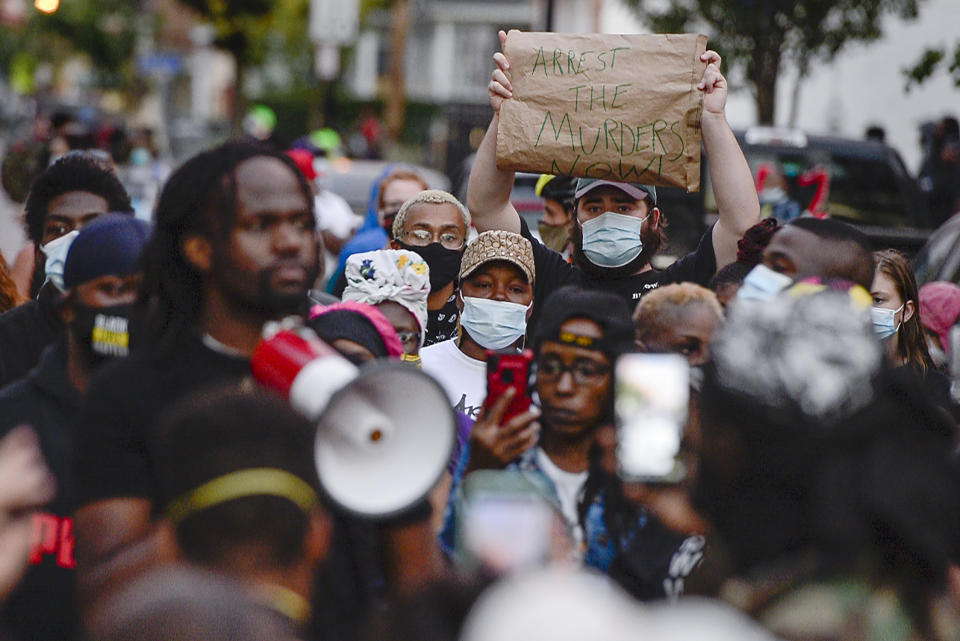 A crowd of protesters gather, Wednesday, Sept. 2, 2020, in Rochester, N.Y., near the site where Daniel Prude was restrained by police officers. Prude, a Black man who had run naked through the streets of the western New York city, died of asphyxiation after a group of police officers put a hood over his head, then pressed his face into the pavement for two minutes, according to video and records released Wednesday by his family. Prude died March 30 after he was taken off life support, seven days after the encounter with police in Rochester. (AP Photo/Adrian Kraus)