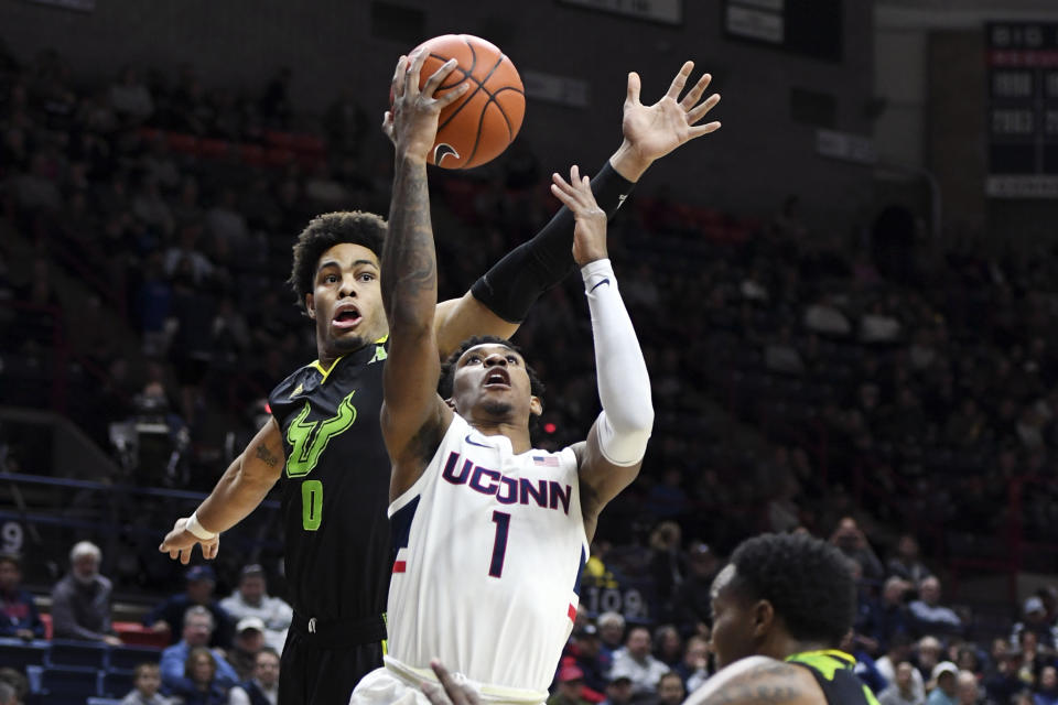 Connecticut's Christian Vital (1) is fouled by South Florida's David Collins (0) during the first half of an NCAA college basketball game Sunday, Feb. 23, 2020, in Storrs, Conn. (AP Photo/Stephen Dunn)
