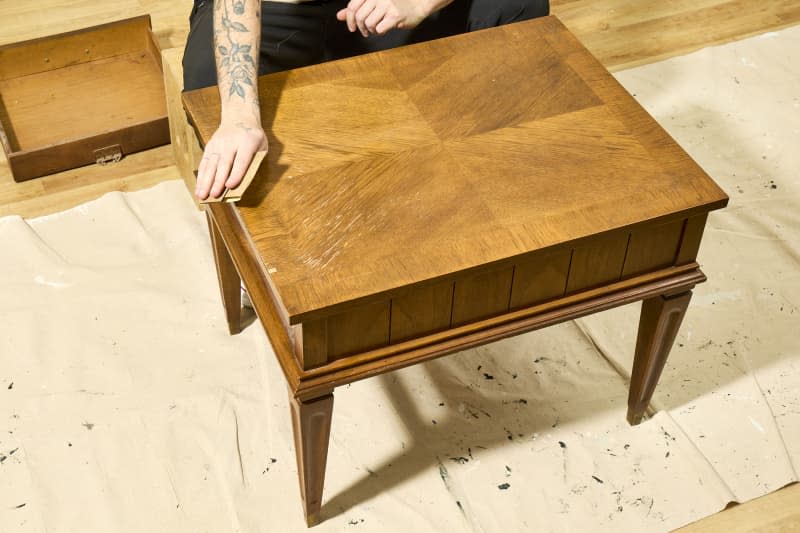 angled shot of the original table being sanded.