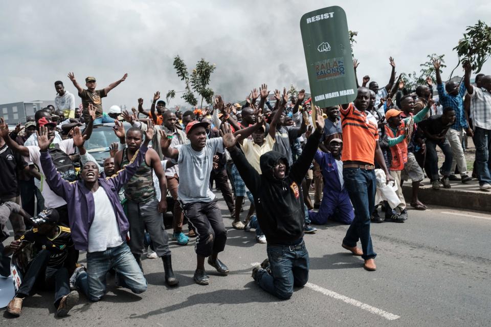 <p>Supporters of Kenyan’s opposition party National Super Alliance (NASA) react when confronted by Kenyan police, as they attempt to march towards the Jomo Kenyatta international airport to welcome opposition leader Raila Odinga upon his arrival on Nov. 17, 2017 in Nairobi. (Photo: Yasuyoshi Chiba/AFP/Getty Images) </p>