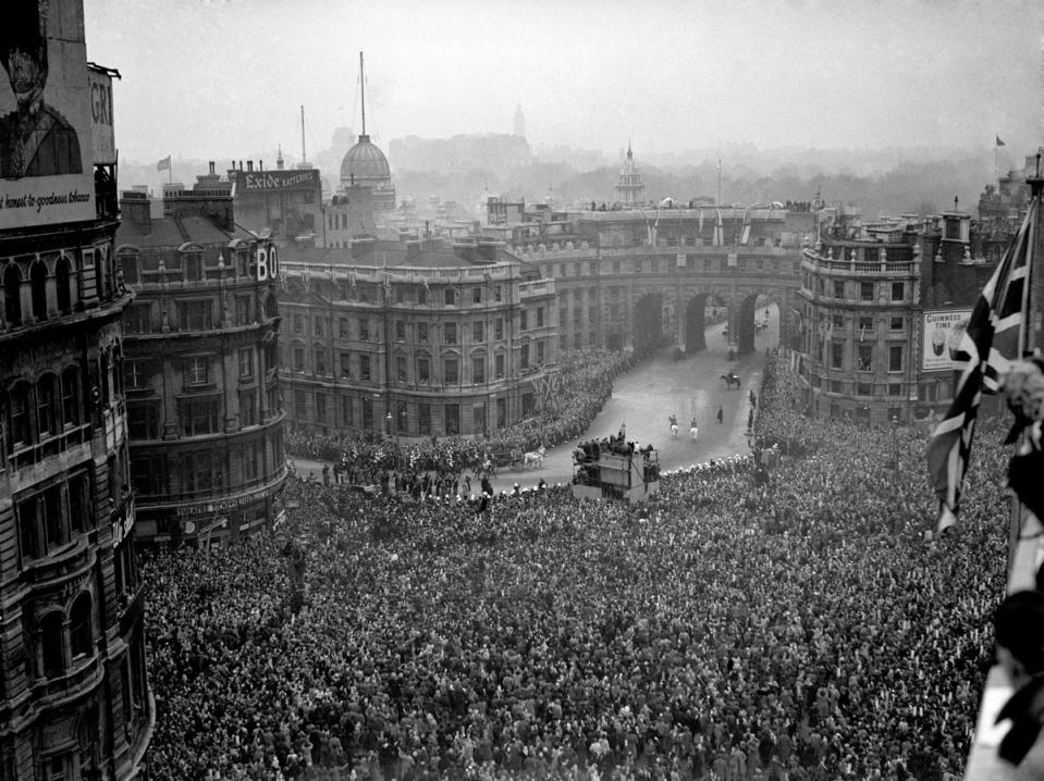 The immense crowd dotted with periscopes in Trafalgar Square waiting for a glimpse of the royal procession through Admiralty Arch on the way to Westminster Abbey (PA )