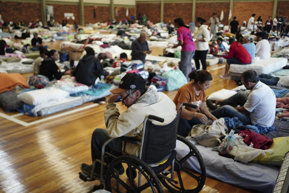 People rest in a shelter after their homes were flooded by heavy rains in Porto Alegre, Rio Grande do Sul state, Brazil, Saturday, May 4, 2024. (AP Photo/Carlos Macedo)