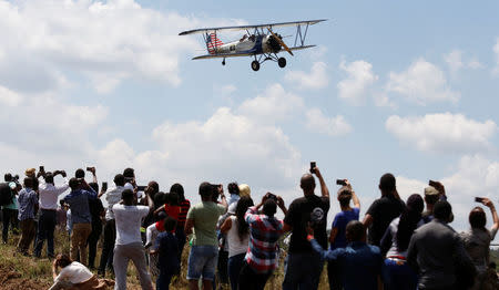 A biplane flies over spectators during the Vintage Air Rally at the Nairobi national park in Kenya's capital Nairobi, November 27, 2016. REUTERS/Thomas Mukoya