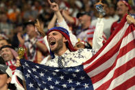 FILE - Supporters cheer on the stands before the World Cup round of 16 soccer match between the Netherlands and the United States, at the Khalifa International Stadium in Doha, Qatar, Saturday, Dec. 3, 2022. At a World Cup that has become a political lightning rod, it comes as no surprise that soccer fans’ sartorial style has sparked controversy. At the first World Cup in the Middle East, fans from around the world have refashioned traditional Gulf Arab headdresses and thobes. (AP Photo/Francisco Seco)