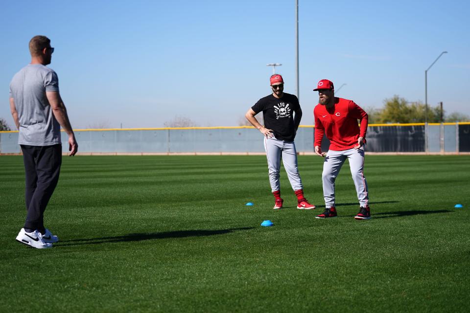 Cincinnati Reds infielder Jonathan India works with first base coach Collin Cowgills on outfield drills during Cincinnati Reds spring training workouts, Saturday, Feb. 17, 2024, in Goodyear, Ariz.