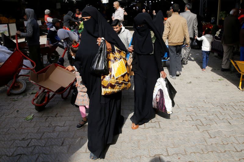 Iraqi people shop at a food market in Falluja