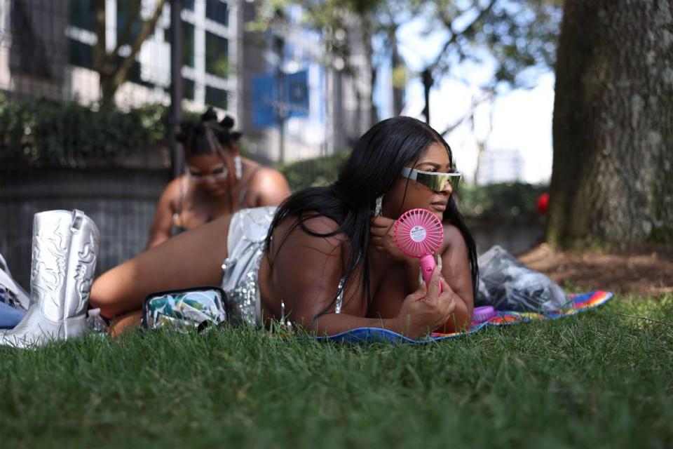 A Beyoncé fan cools off with a handheld fan while waiting for the superstar Renaissance World Tour at the Queen City on Wednesday, Aug. 9, 2023. Fans started to gather outside Bank of America Stadium early in the afternoon for the 8pm concert.