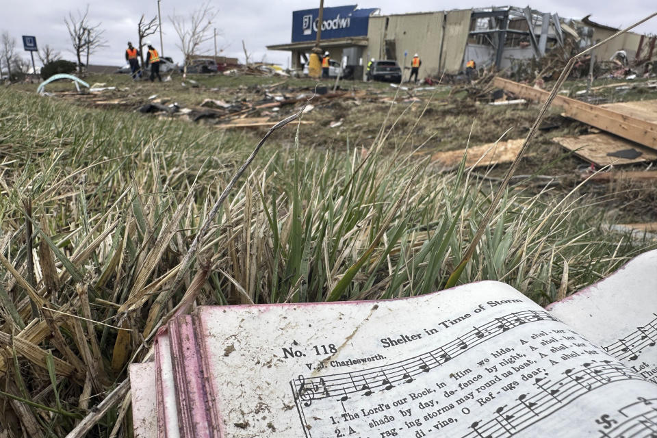 A hymnal book from a destroyed church across the street is seen among the debris strewn in Winchester, Ind., on Friday, March 15, 2024, after storms ripped through the area Thursday night. (AP Photo/Isabella Volmert)
