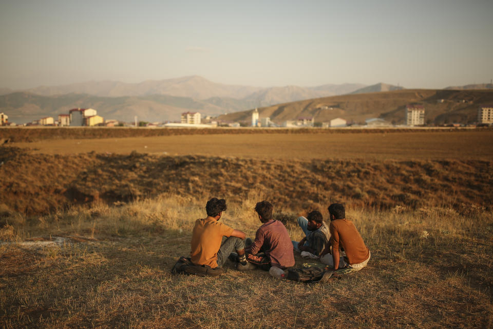 Young men who say they deserted the Afghan military and fled to Turkey through Iran sit in the countryside in Tatvan, in Bitlis Province in eastern Turkey, Tuesday, Aug. 17, 2021. Turkey is concerned about increased migration across the Turkish-Iranian border as Afghans flee the Taliban advance in their country.(AP Photo/Emrah Gurel)