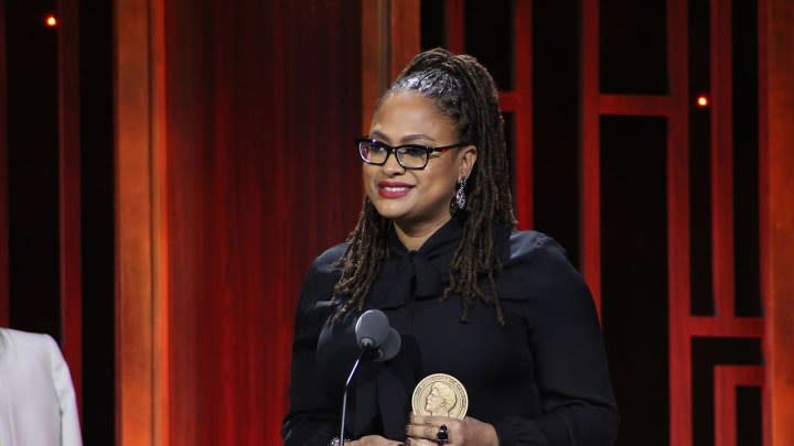 Ava DuVernay standing at a podium accepting an award.