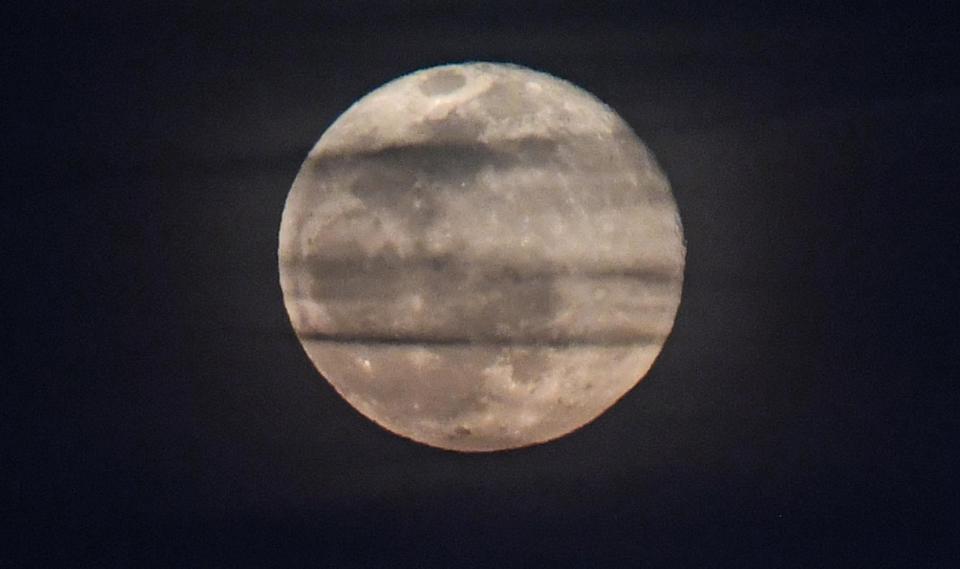 A Snow Full Moon rises during the top of the tenth inning during the Reedy River Rivalry at Fluor Field in Greenville, S.C. Saturday, February 27,2021.    