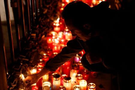 A man places a candle on the Love monument during a silent candlelight vigil to protest against the assassination of investigative journalist Daphne Caruana Galizia in a car bomb attack, in St Julian's, Malta, October 16, 2017. REUTERS/Darrin Zammit Lupi