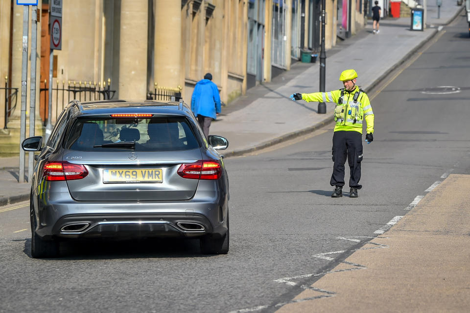 Police stop motorists as they travel on Park Street, Bristol, where random checks on essential travel are taking place as the UK continues in lockdown to help curb the spread of the coronavirus.